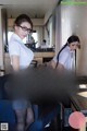 A woman in a skirt and glasses is sitting at a desk.